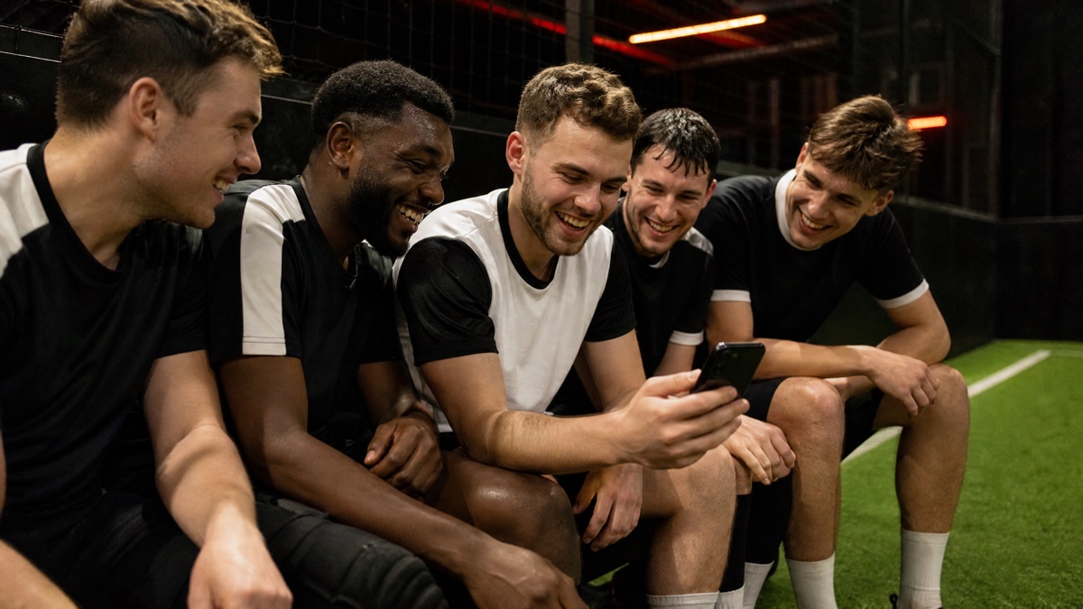 Des joueurs regardent un téléphone après un match de foot en salle