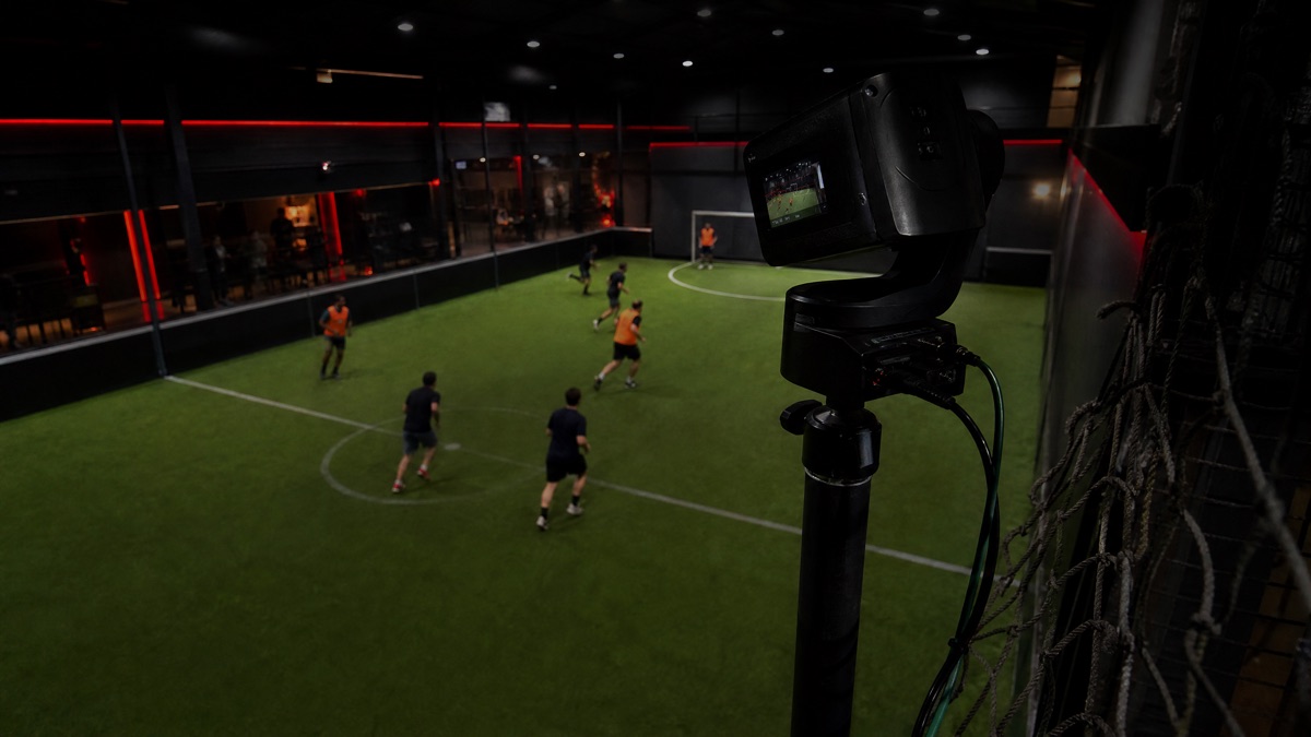 Une caméra filme un match sur un terrain de foot en salle